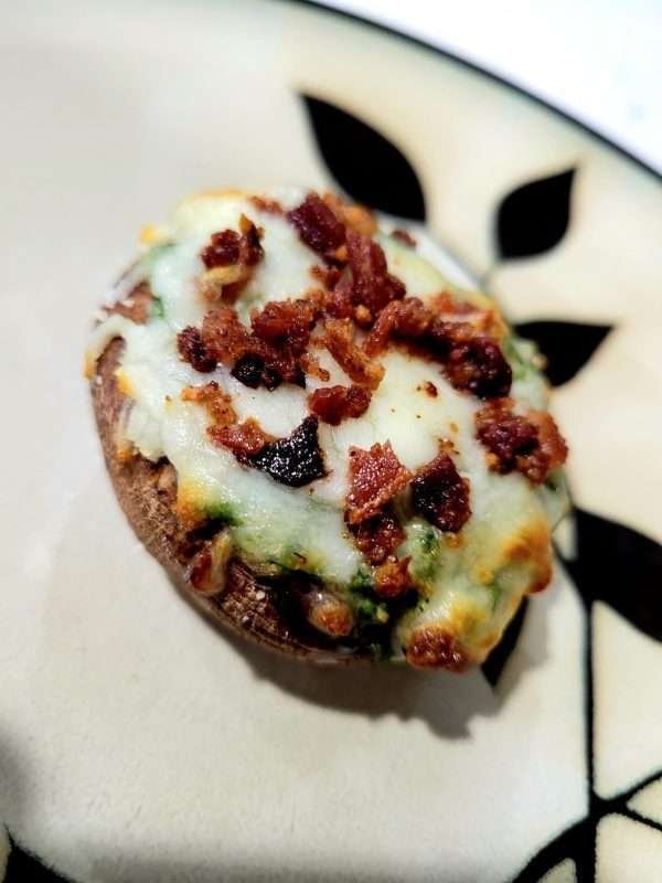Savory stuffed portobello mushroom topped with melted cheese and crispy bacon bits, ready to be served