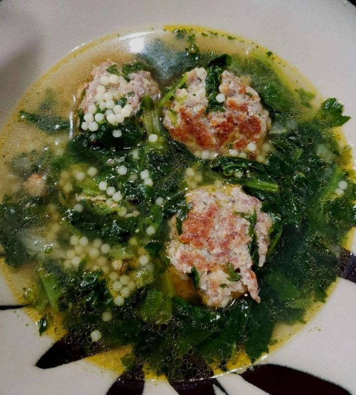 Comforting bowl of Italian wedding soup with meatballs, spinach, and parmesan, symbolizing the warmth of Italian culinary tradition